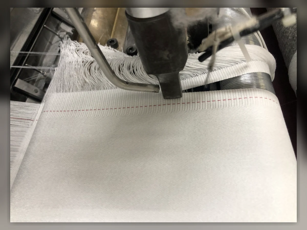 Original close-up photograph of fabric formation and selvedge on a loom